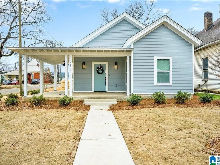 New blue Woodlawn United home with front porch, walkway, and landscaped yard in Birmingham.