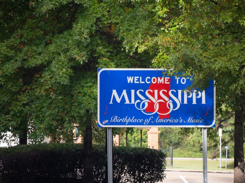 Red, white, and blue sign to welcome travelers to Mississippi, affordable housing grants mississippi