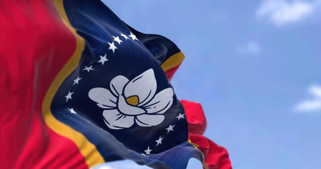 The US state flag of Mississippi waving in the wind. Mississippi is a state in the Southeastern region of the United States. Democracy and independence; affordable housing grants mississippi