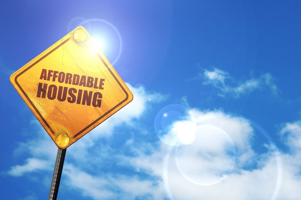 affordable housing, 3D rendering, glowing yellow traffic sign; affordable housing month