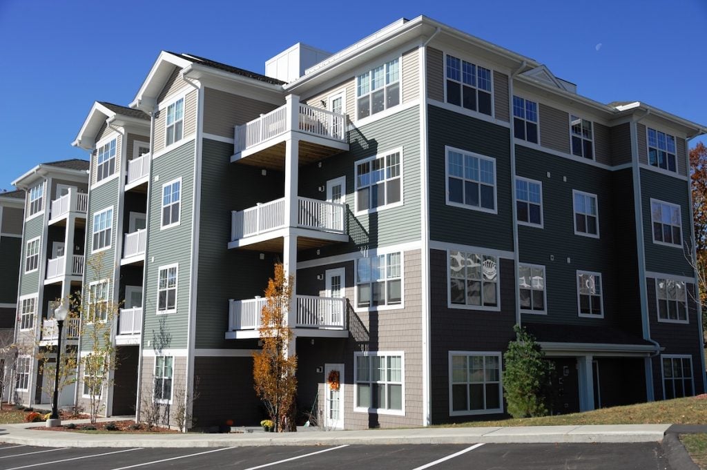 Modern affordable housing apartment building representing PBRA vs vouchers for families.