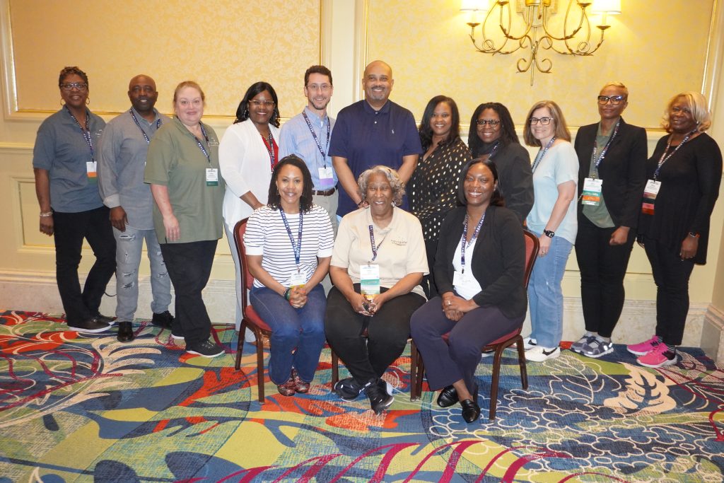 Navigate team members pose for a group photo at a housing conference.