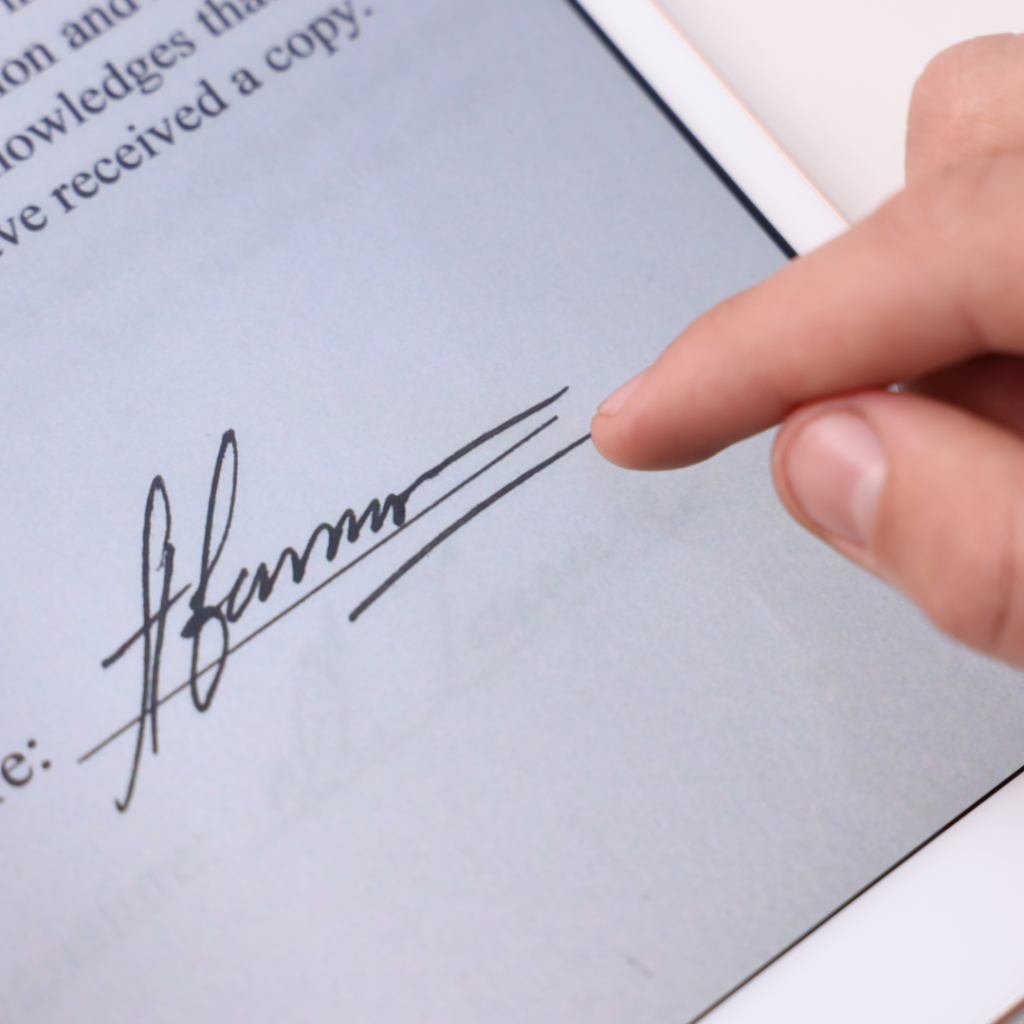 A finger signing a form on a tablet
