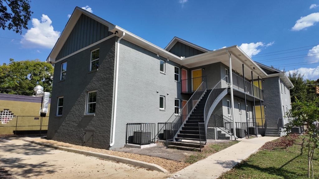 A gray brick apartment building with stairs