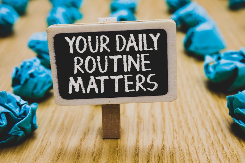 Handwriting text writing Your Daily Routine Matters.. Concept meaning Have good habits to live a healthy life Stand blackboard with white words behind blurry blue paper lobs woody floor; housing quality habits