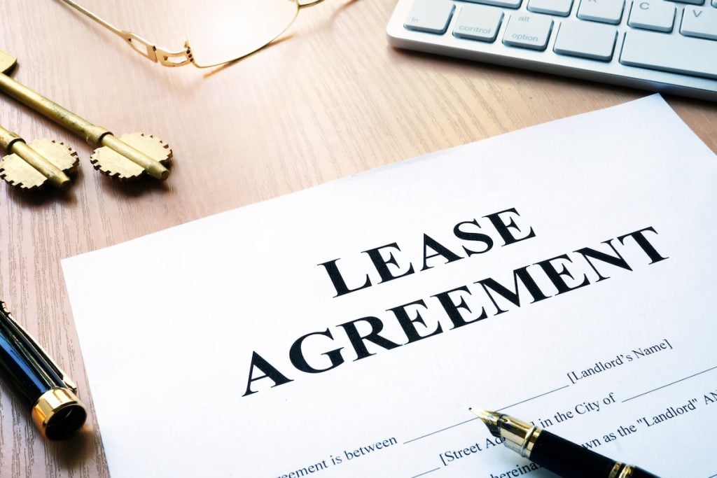 Rental lease agreement form on an office desk, HOTMA lease addenda